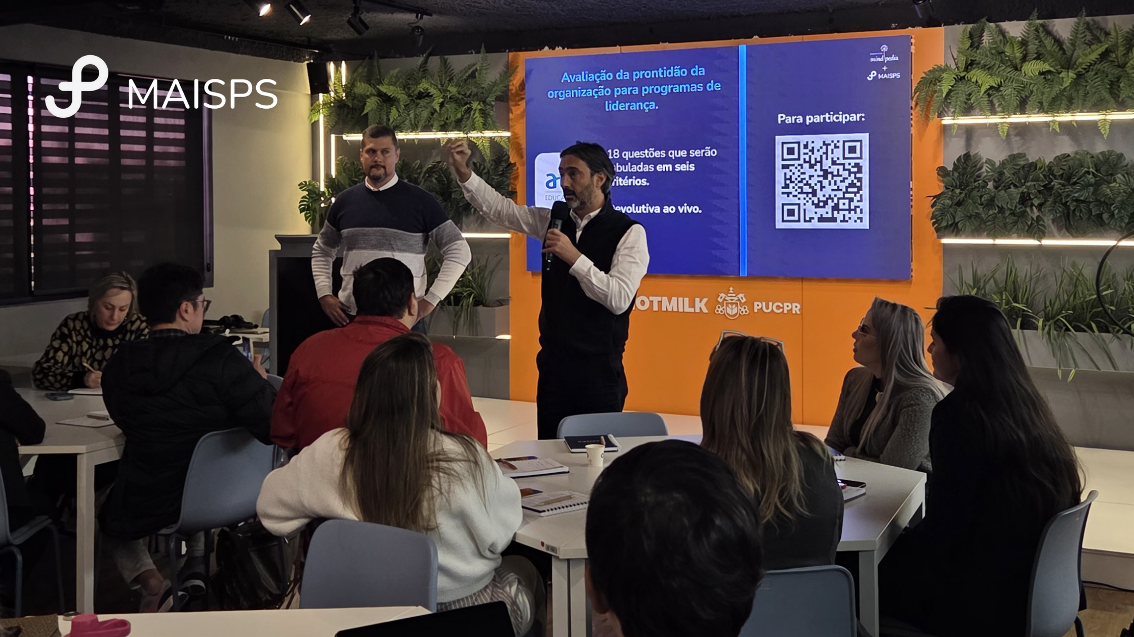 Daniel Spinelli conduz palestra de liderança e desenvolvimento de competências em sala, com participantes acompanhando apresentação sobre prontidão organizacional para programas de liderança.